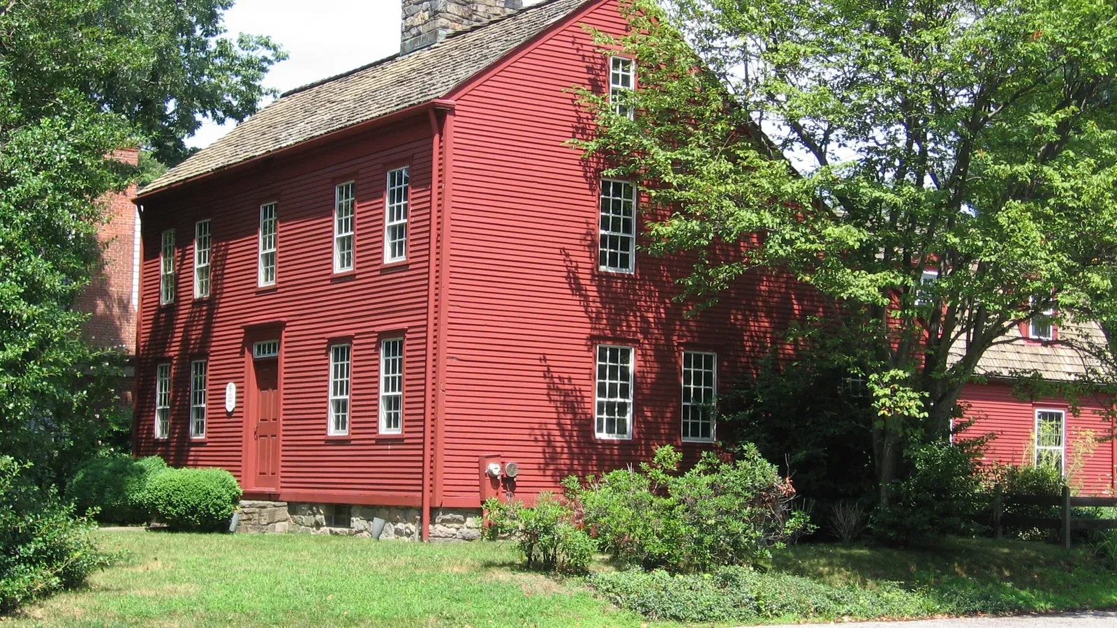 Red clapboard Bates-Scofield House, an eighteenth-century saltbox museum in Darien, Connecticut